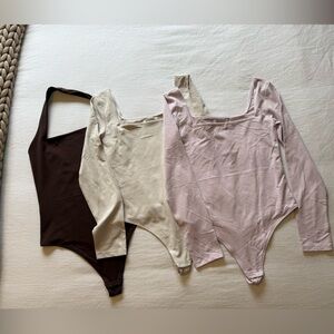 Aritza Bodysuit Set of Three Long Sleeve Bodysuits in Brown, Cream, and pink